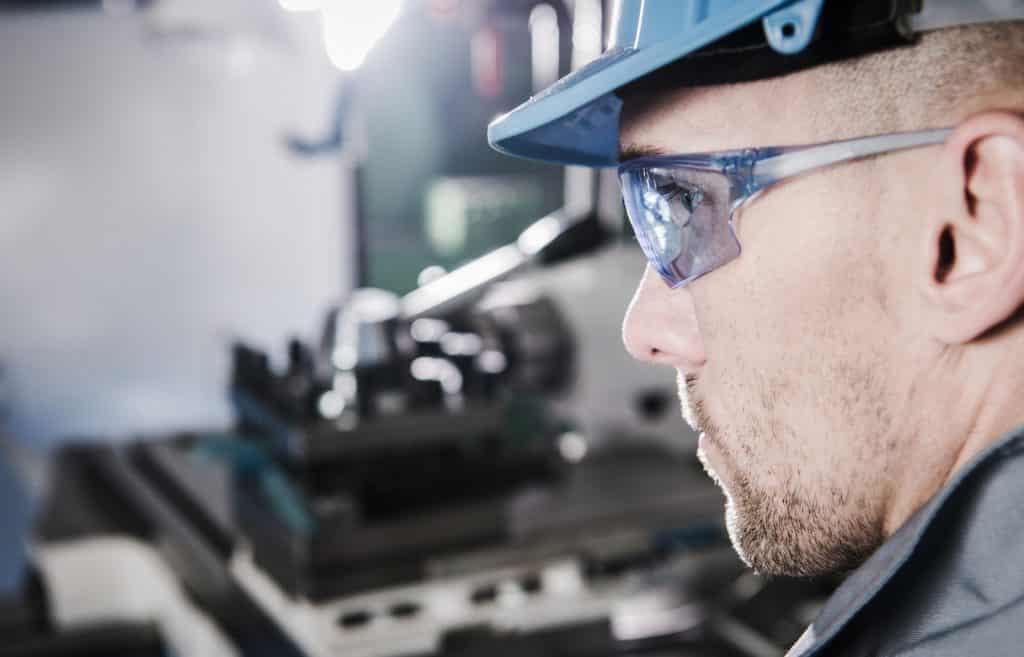 Caucasian Industrial Worker Wearing Safety Glasses and Hard Hat. Closeup Photo.